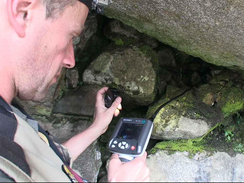 Caméra endoscopique introduite au travers des pierres qui bouchent l'entrée