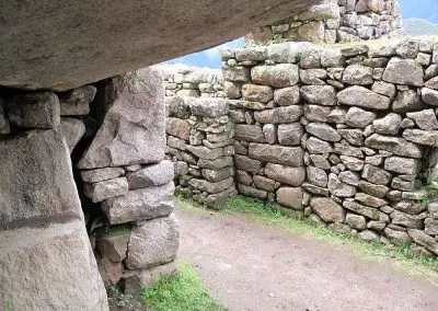 Le bâtiment face à l'entrée bouchée n'est pas aligné avec les murs des édifices mitoyens. Il semblerait avoir été construit plus tard masquant ainsi une petite esplanade devant la porte, sans doute utilisée pour des cérémonies d’offrandes en liaison avec le Temple des Trois Portes.